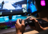 EuroGamersOnline Review 2026 Gamer using a controller on a modern PC gaming setup with RGB keyboard and monitor.