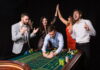 Store.WineTurtle.com No Deposit Bonus: Claim Guide Players celebrating at a roulette table while claiming a Store.WineTurtle.com no deposit bonus offer.