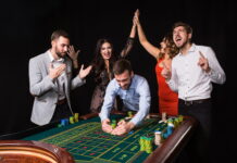 Store.WineTurtle.com No Deposit Bonus: Claim Guide Players celebrating at a roulette table while claiming a Store.WineTurtle.com no deposit bonus offer.